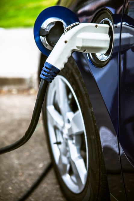An electric car hooked up to a charging terminal
