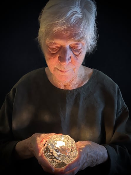 Ann Wolff, 86, holding one of the snowball candle holders she designed.