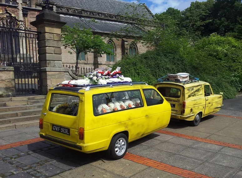 It comes with a matching yellow trailer that holds the coffin itself