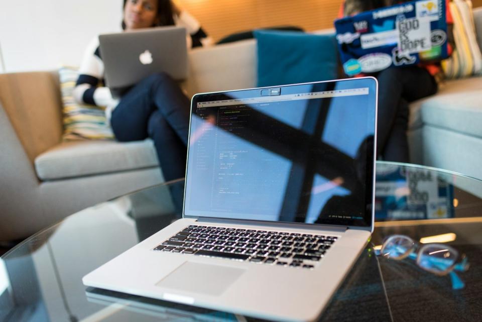 Here are some general business ideas for those thinking "I want to start a business but have no ideas. Pictured: an open laptop on a table and two people behind it sitting down.