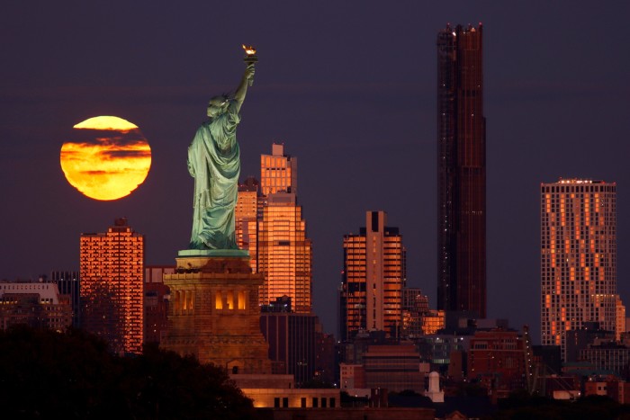 The Brooklyn Tower at night with the Statue of Liberty in the foreground