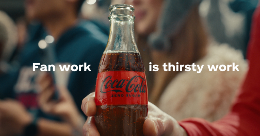 A Coke Zero Sugar bottle with the words Fan Work is Thirsty Work.