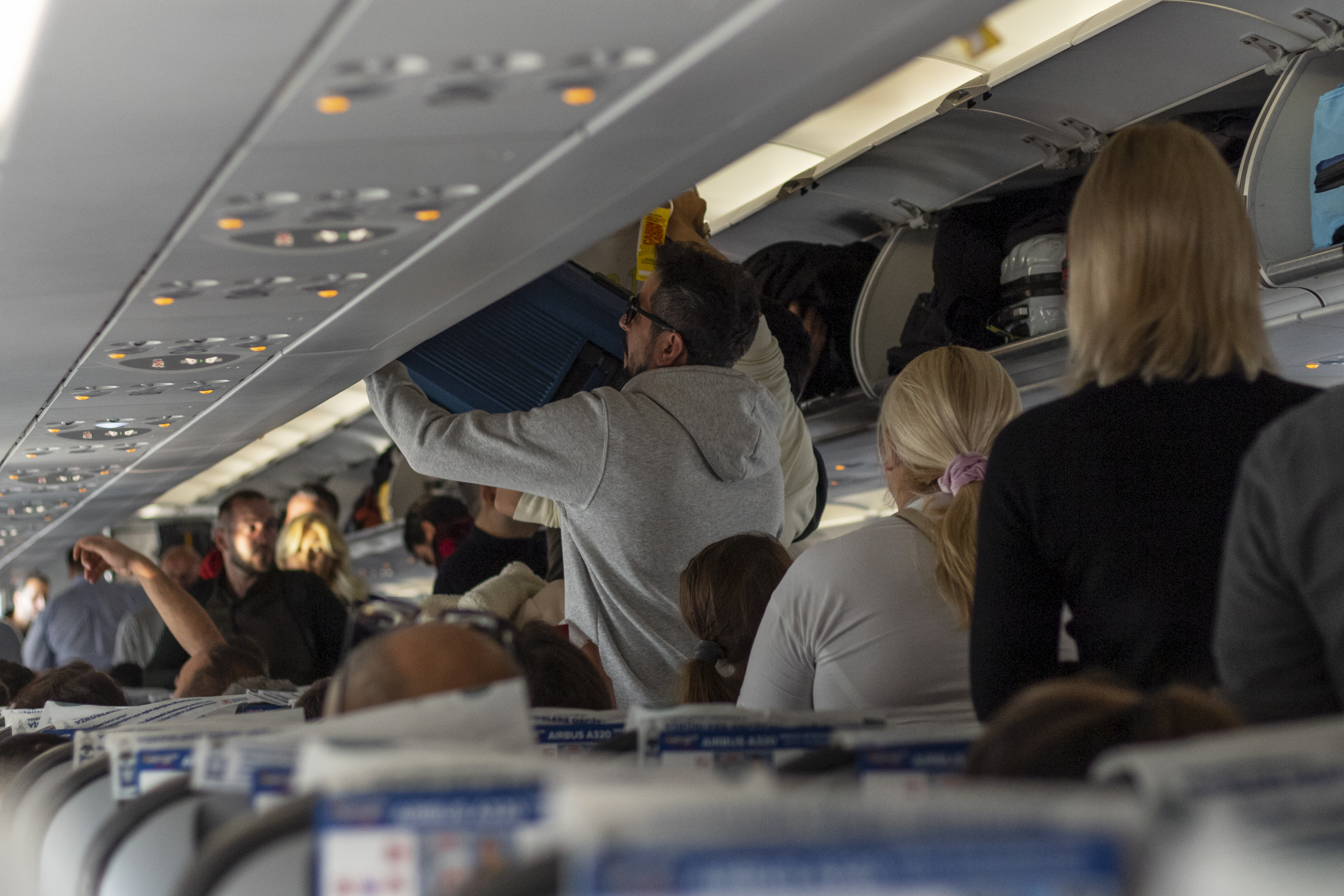 Passengers seen fighting for space in the overhead lockers