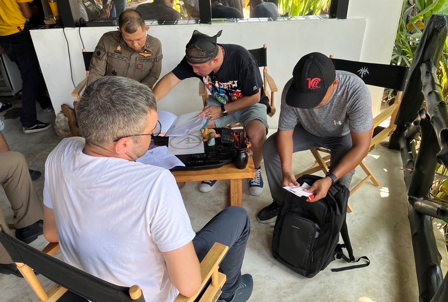 Police interrogate Ibragim Gaitukiev, 36, a Russian national, at a house on Sri Thanu beach in tambon Koh Phangan of Surat Thani province on Thursday. The house also served as a cannabis shop and cryptocurrency exchange. (Photo: Surat Thani police)