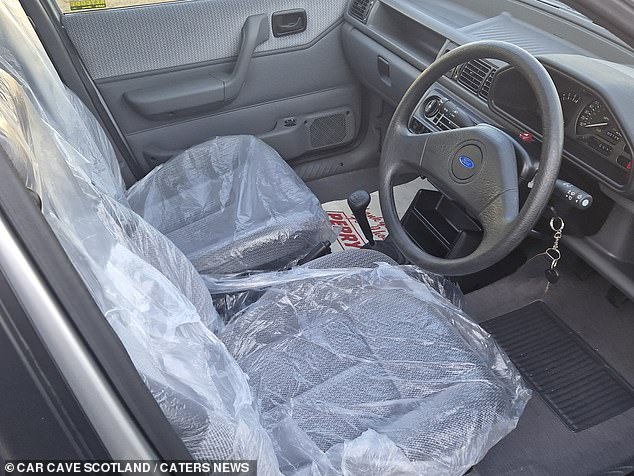 The interior looks unused, with seat covers still in place to protect the cloth seats