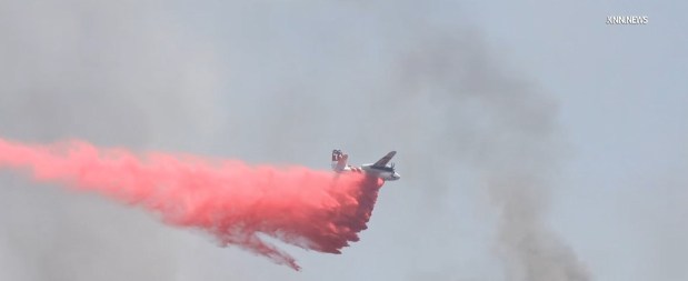 A firefighting plane drops retardant Saturday on the Round fire east of Moreno Valley. (Photo by contributing photographer Marc Danielian/KNN)