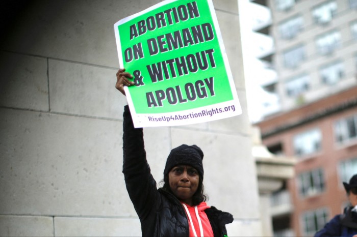 A demonstrator holds a sign reading ‘Abortion on demand & without apology’