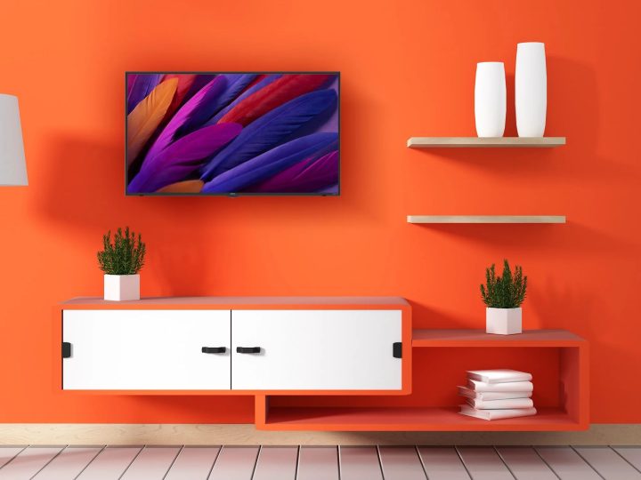The Onn. 43-inch Class 4K LED Roku Smart TV on an orange wall.
