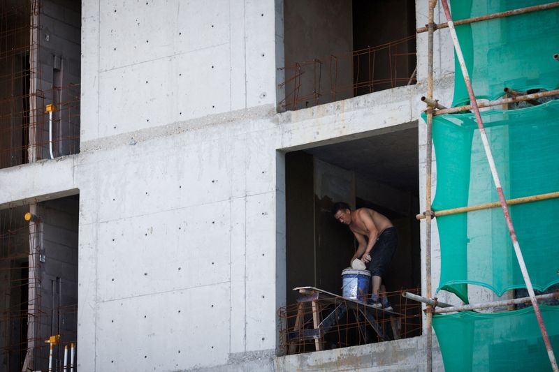 © Reuters. FILE PHOTO: A man works at a construction site of apartment buildings in Beijing, China, July 15, 2022. REUTERS/Thomas Peter/File Photo
