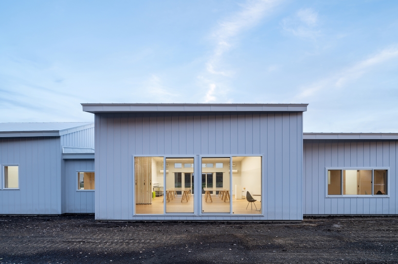 a series of small gabled homes forms atelier meme's specialized school in japan