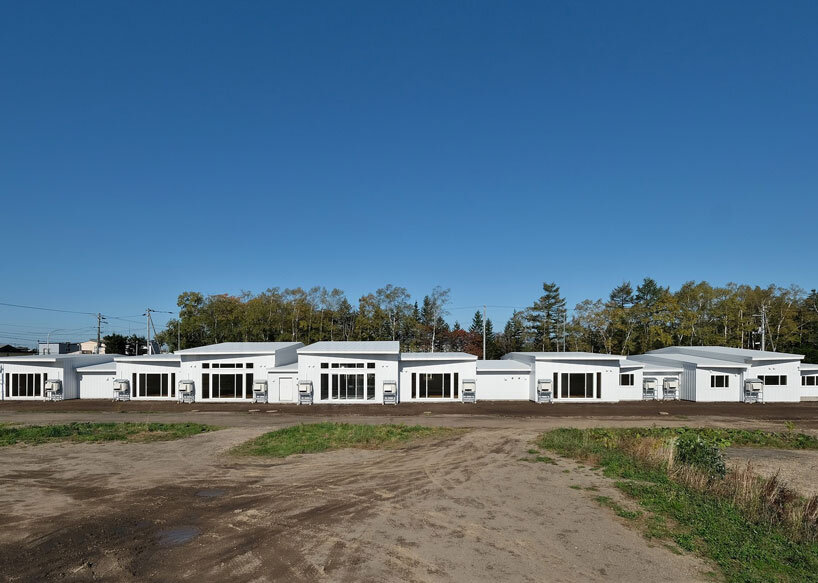 a series of small gabled homes forms atelier meme's specialized school in japan