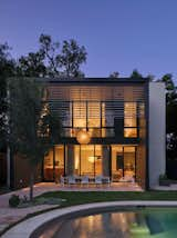 A central courtyard awaits inside this newly constructed home south of downtown Austin. The exterior’s board-formed concrete, steel, and stucco elements complement the warm walnut, industrial steel, and smooth plaster within. A two-story dining porch with a steel louvered screen offsets the home’s southern exposure and provides privacy for the upper-level bedrooms. 