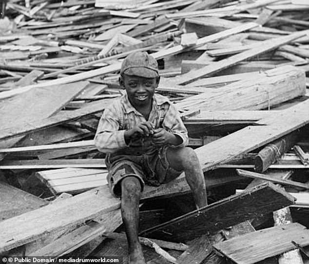 A child sits on piles of rubble following the deadly Galveston Hurricane. More than 8,000 people were killed, most drowned or crushed