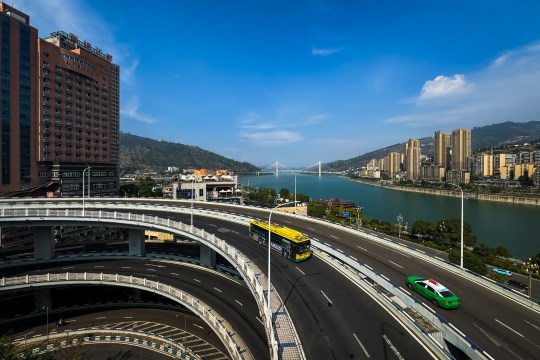 A view of the U-shaped overpass near the confluence of the Wujiang River and the Yangtze River, with the Shibangou Yangtze River Bridge visible in the distance.