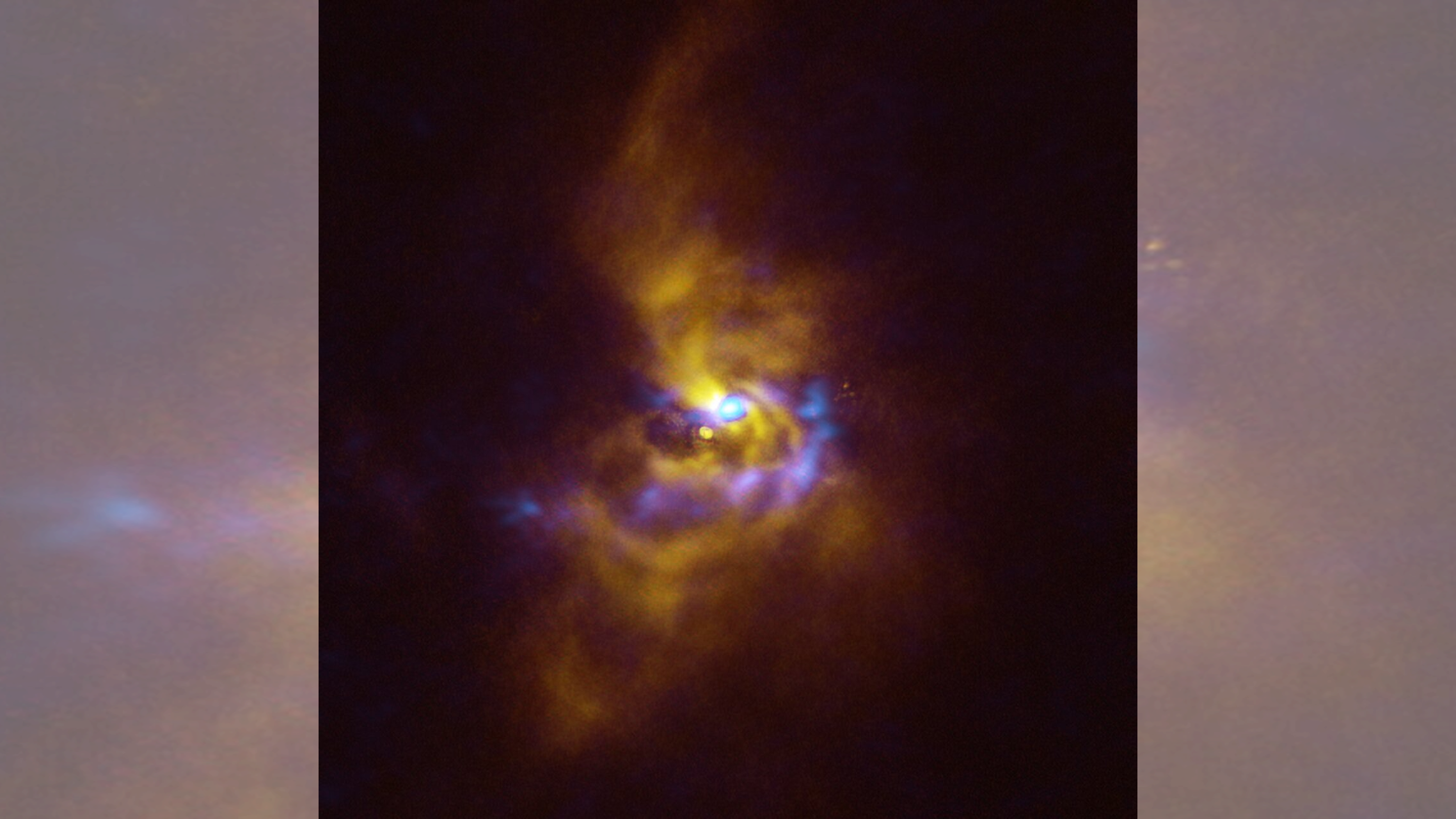 Four spirals of yellow gas swirl around a distant star. At the center, blue blotches reveal where gas is collapsing into new planets