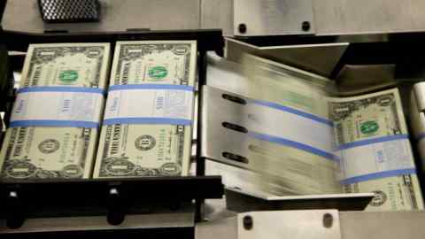 US dollar notes being put in packaging bands by a machine