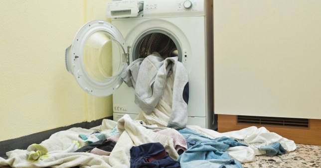 front loader washing machine with clothes falling out of it 