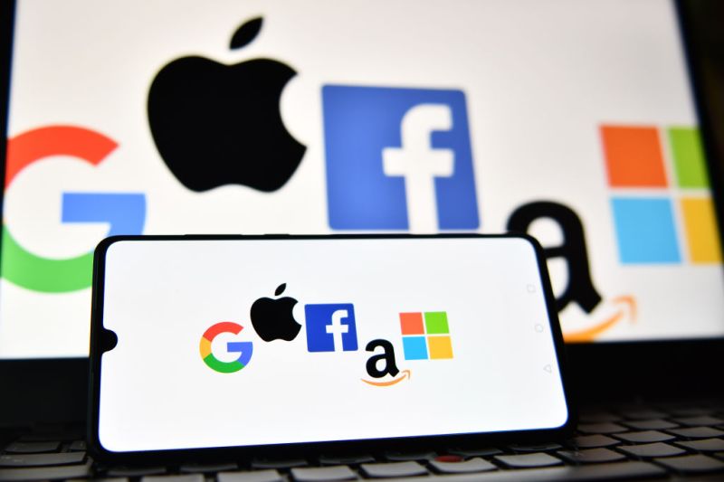 An illustration picture taken in London on December 18, 2020 shows the logos of Google, Apple, Facebook, Amazon and Microsoft displayed on a mobile phone and a laptop screen. (Photo by JUSTIN TALLIS / AFP) (Photo by JUSTIN TALLIS/AFP via Getty Images)