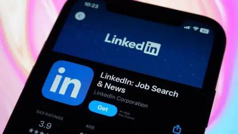 Getty Images LinkedIn's listing on Apple's App Store displayed on an iPhone screen in a close-up shot, against a colourful pink, blue and purple background.