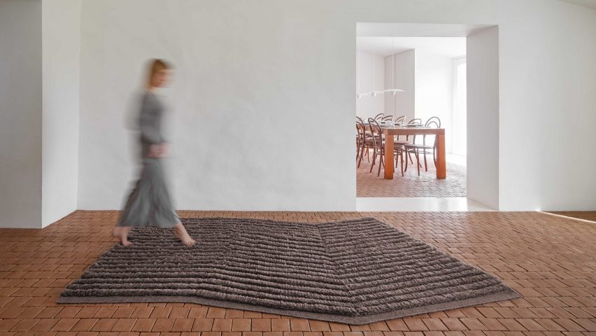 Person walking across grey rug