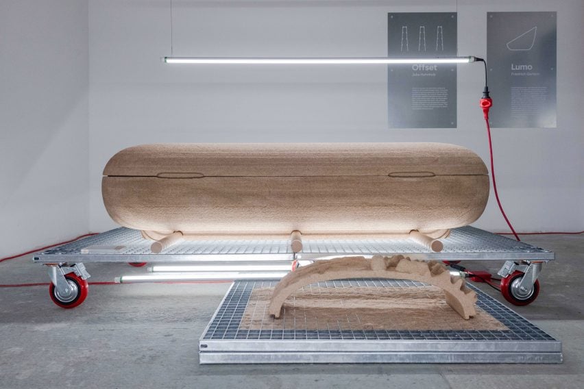 Photo of a smooth and rounded coffin with a cork-like colour and texture made from 3D-printed wood material EconitWood