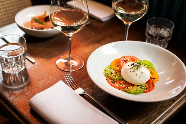 A starter of Burrata served with colourful tomatoes in a restaurant in London