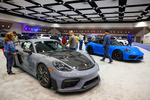 Visitors look at the Porche 718 Cayman GT4 RS on display during the 2025 Silicon Valley Auto Show at the Santa Clara Convention Center in Santa Clara, Calif., on Friday, Feb. 21, 2025. Attendees explored the latest vehicles from 17 manufacturers, the chance for test drives, and a demo of a TOboR Home Dog. The show runs from Friday, Feb. 21, through Sunday, Feb. 23. (Ray Chavez/Bay Area News Group)