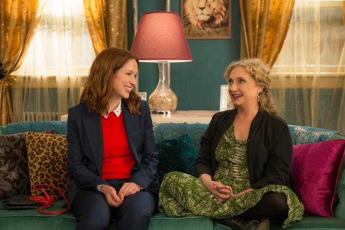 Two women sit on a couch, engaged in conversation