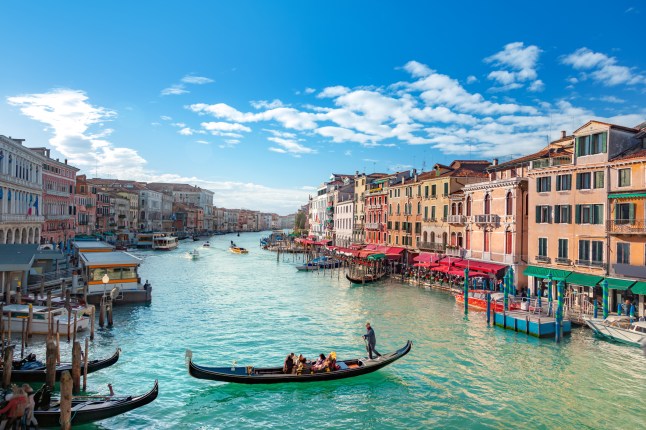 A gondola cruising through the crowded canals of Venice, Italy.