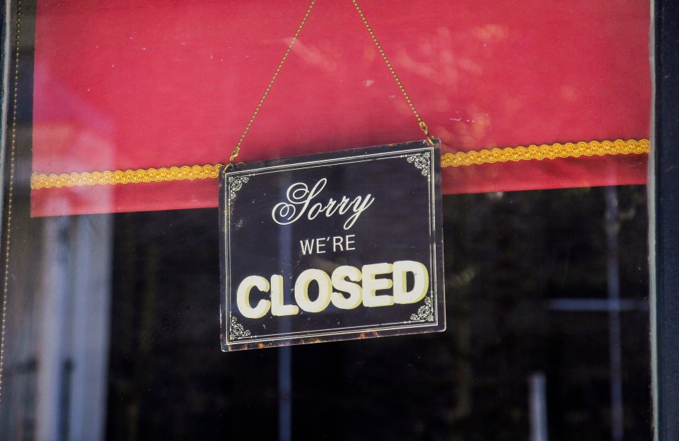 "Sorry, we're closed" sign in a window.