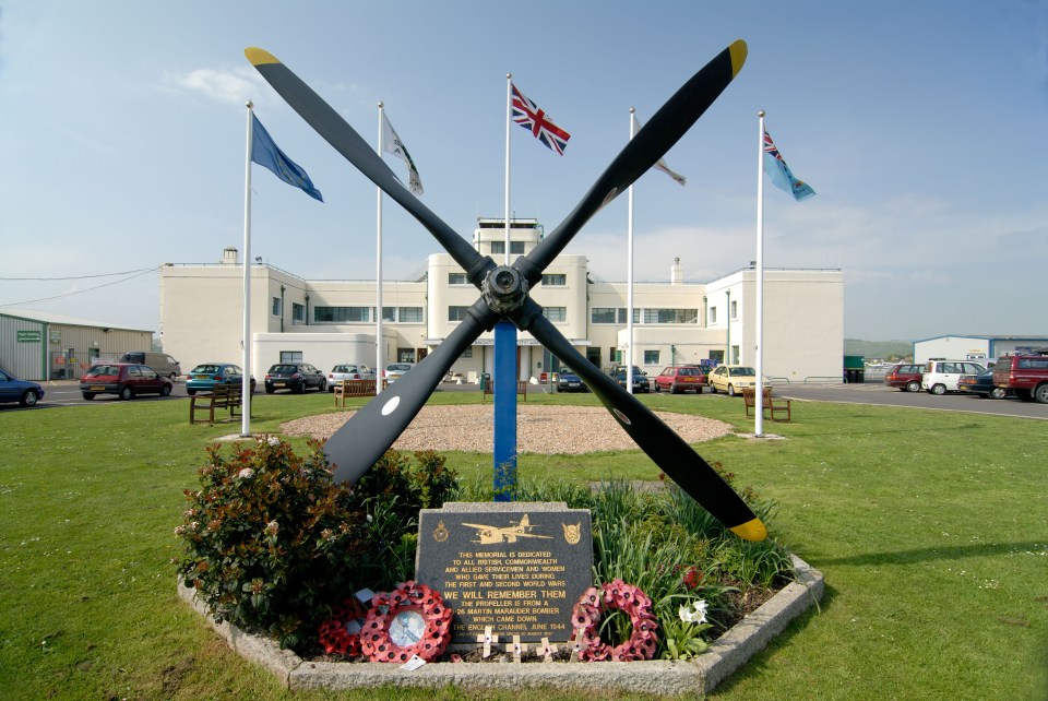 Memorial at Shoreham Airport with airplane propeller and wreaths.