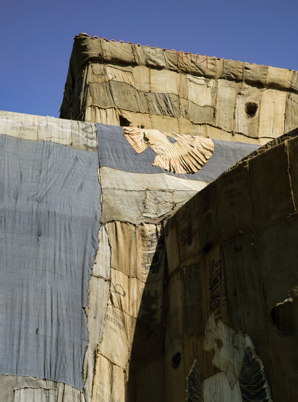 ibrahim mahama wraps kunsthalle bern in jute sack veil, confronting histories of labor & trade
