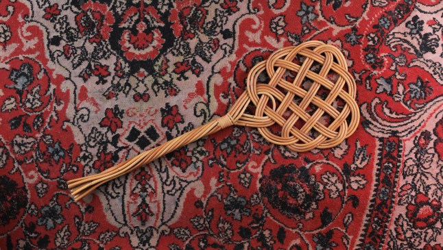 A carpet beater on a rug