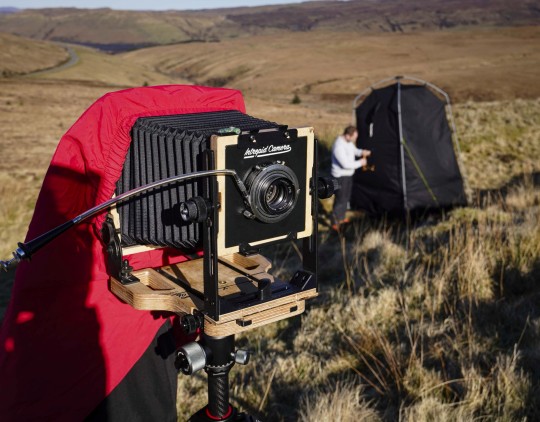 Photographer Simon Riddell, 41, who is scaling the Cuillin Mountain on Skye to take incredible Victorian-style photographs. See SWNS story SWNAphoto. A photographer is scaling a mountain to take incredible Victorian style pictures using a rare process - invented nearly 200 years ago. Simon Riddell, 41, took up wet plate collodion in 2020 to help with his mental health and said the complicated process is used by just a handful of people around the world. Invented in 1851, it sees photographic material, usually glass or aluminium coated in collodion, sensitised in a silver nitrate bath, and developed within ten minutes.