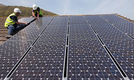 Two men in hard hats handling panels