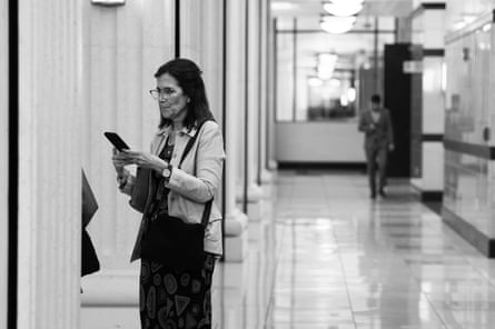 woman looks at phone in hallway