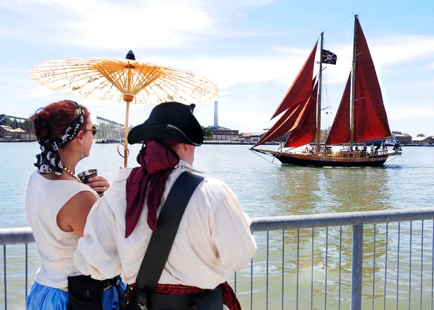 David and Debra Moorhouse from Sacramento watch the pirate ship Aldebaran pass along the Vallejo waterfront during the ship-to-shore cannon battle during the Northern California Pirates Festival. (Chris Riley/Times-Herald)