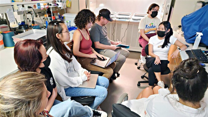 students sitting around teacher