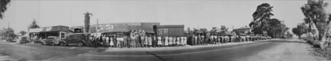 A black-and-white image of a low-slung building on a street bordered by trees. The image is made up of many images in a row, so you can see up and down the street.