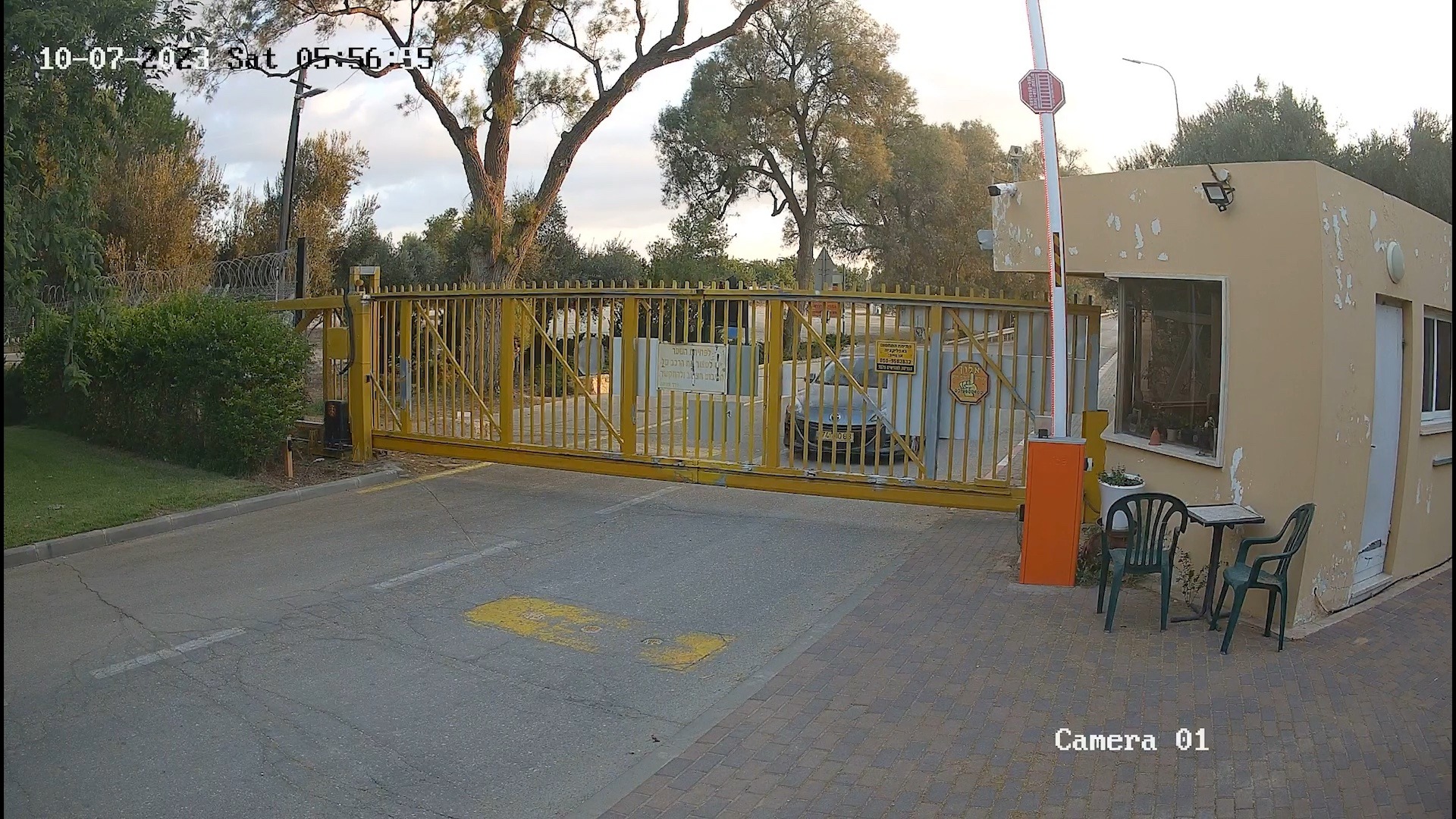 A car waits as a yellow gate opens in front of it