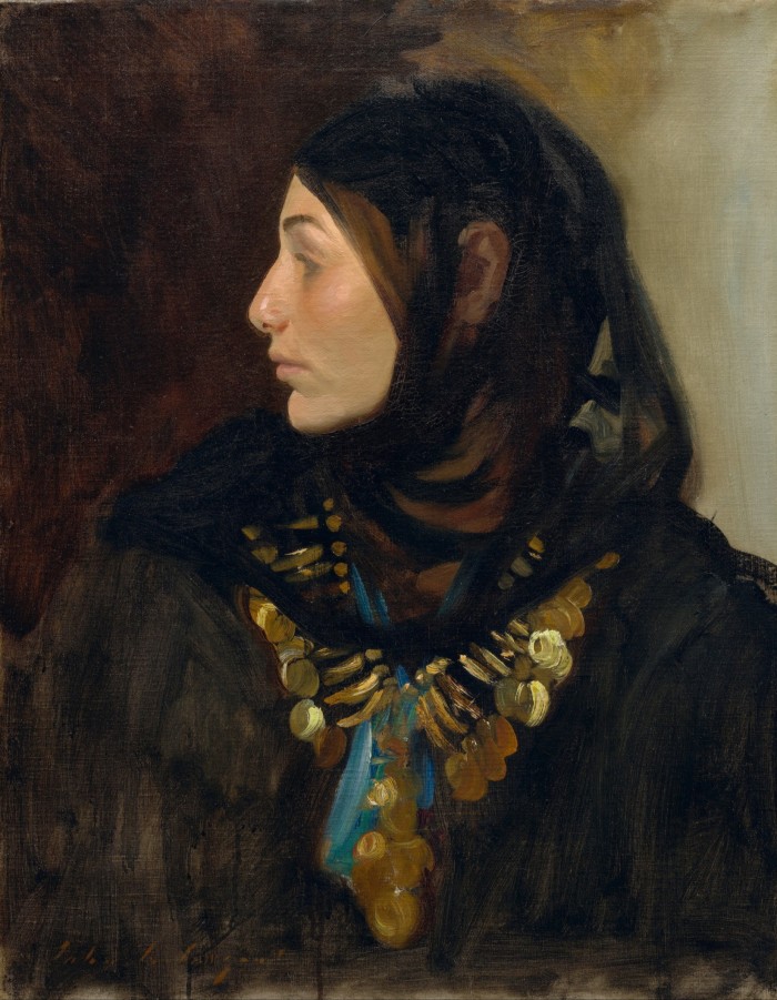 Profile portrait of a woman in black headscarf wearing a coin necklace