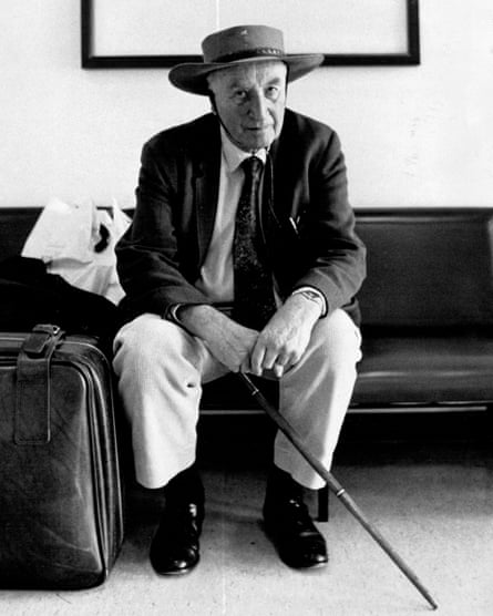 Black and white photo of Peter Wright sitting on a bench with a cane in his hand