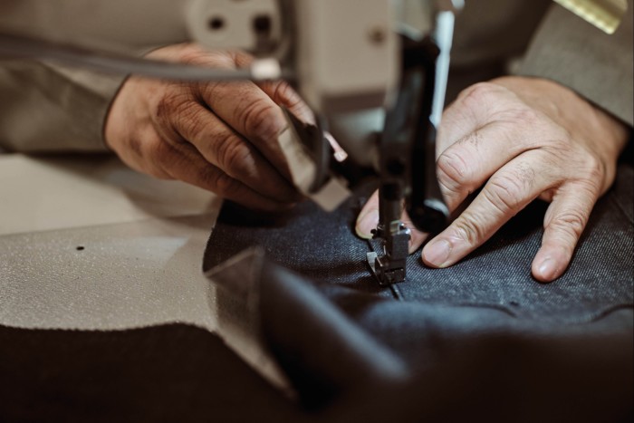 A man’s hands using a sewing machine