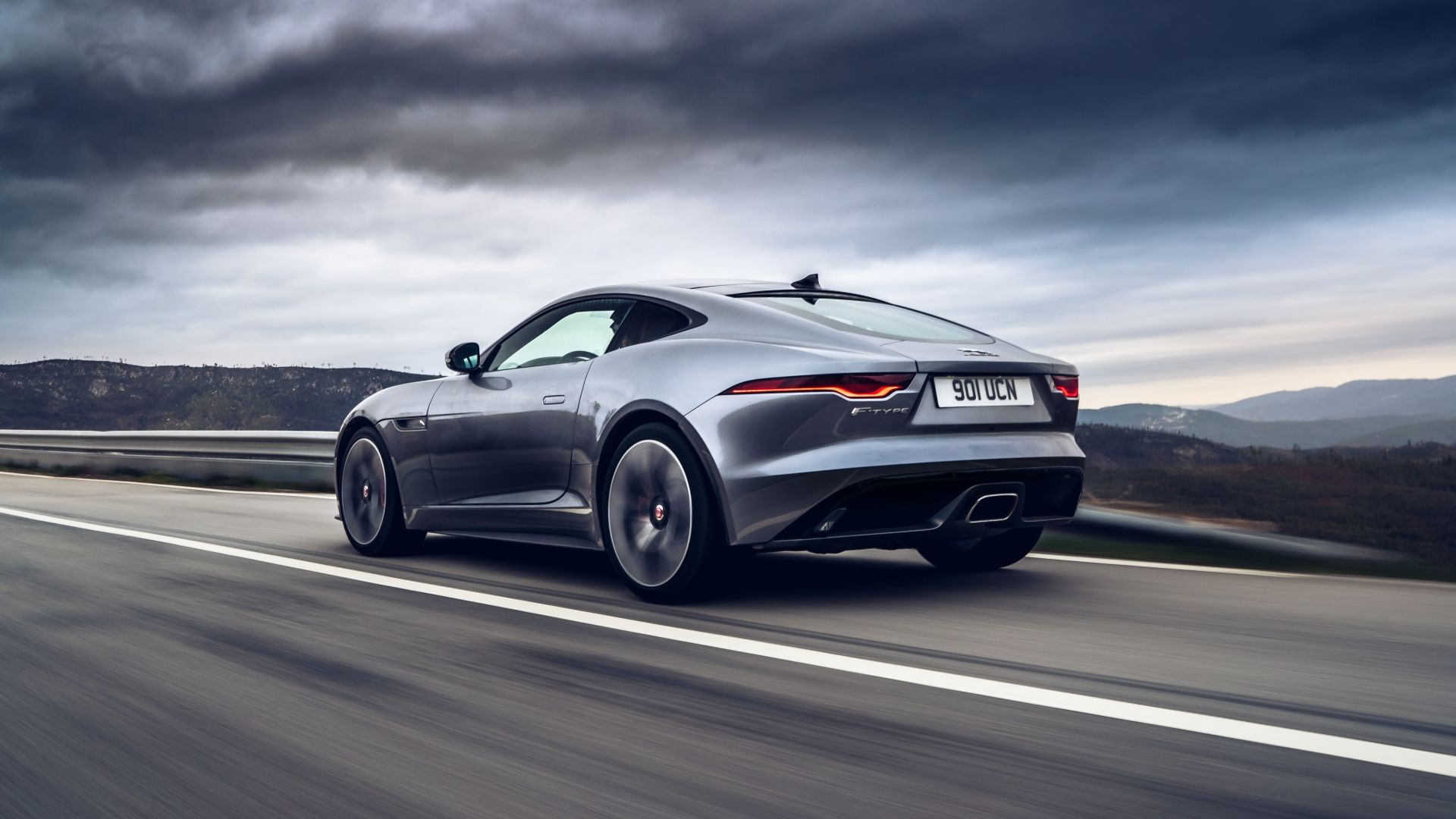 A grey 2020 Jaguar F-TYPE P300 Coupé RWD seen in a rear 3/4 action shot