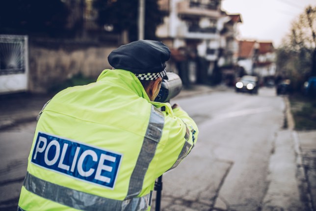 Traffic police officer measuring people's speed pictured