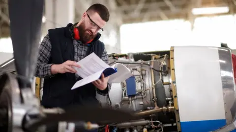 Getty Images An aerospace engineer reading an instruction manual