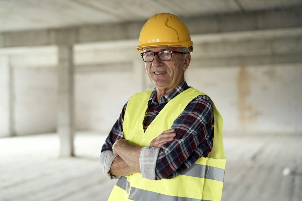 Senior caucasian man holding plans on the construction site