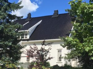 sort tak og hvit fasade på hus med seks vinduer