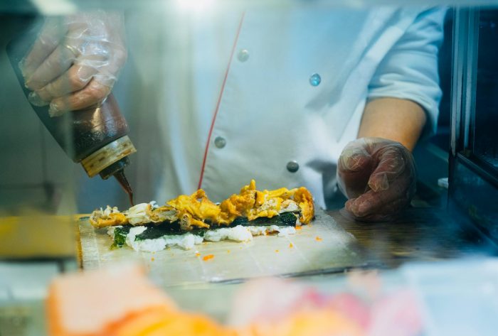 cooks hands in gloves over food