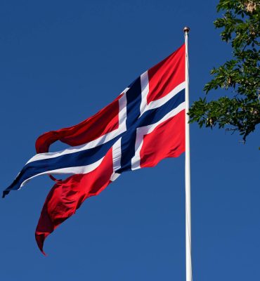 torn flag of norway billowing in the wind